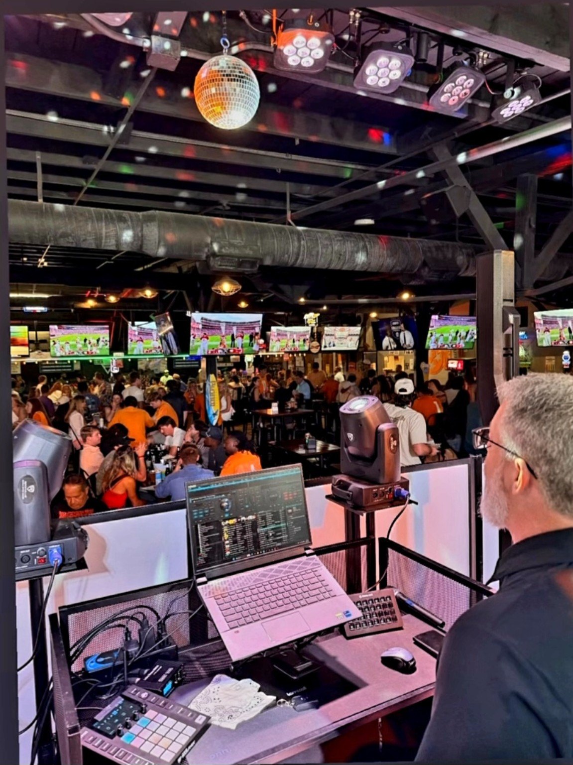 Adam running the Ultimate Game Day Experience with a room full of Tennessee fans and football on the screens at The Local Smokey
